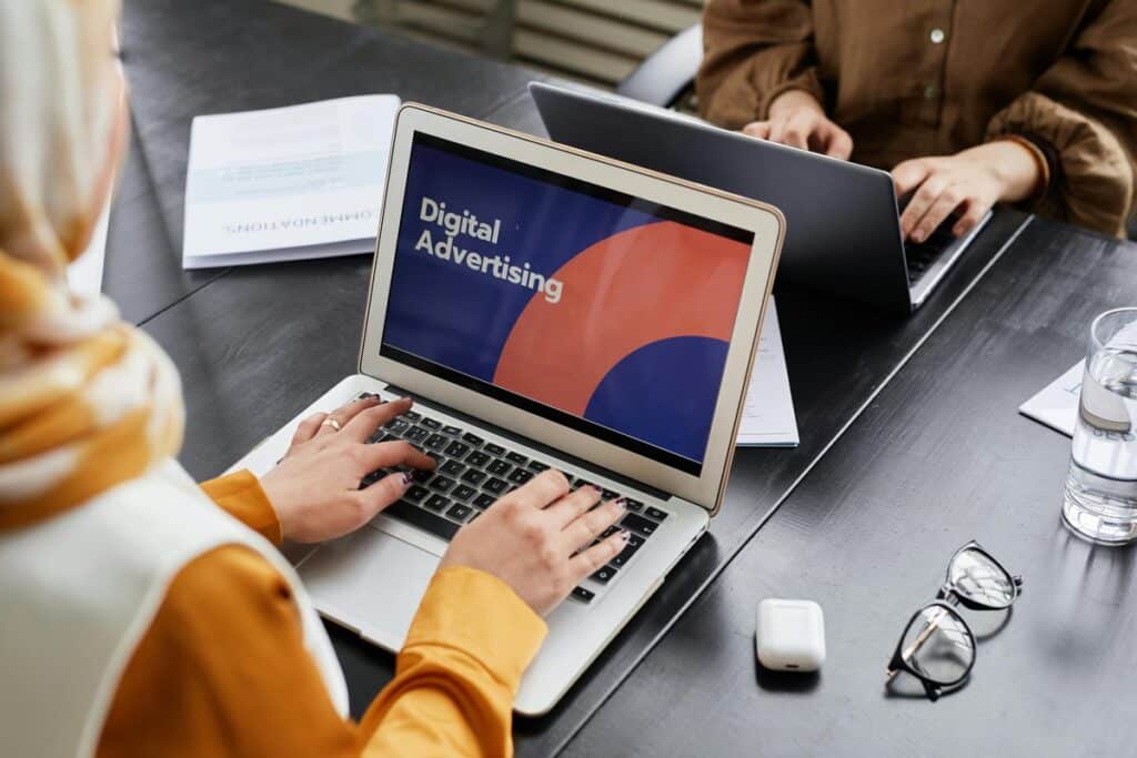 Dwie osoby pracujące przy laptopach przy jednym stole