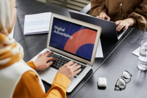 Dwie osoby pracujące przy laptopach przy jednym stole